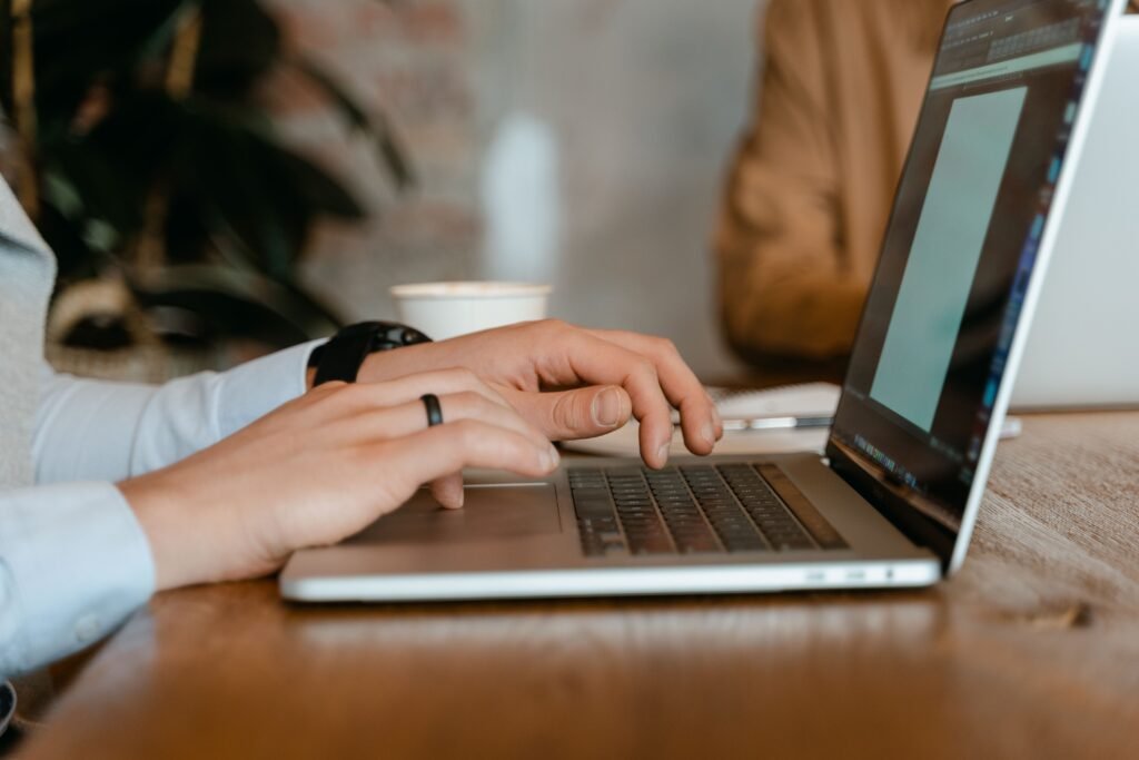 Close-up of hands working at a laptop keyboard